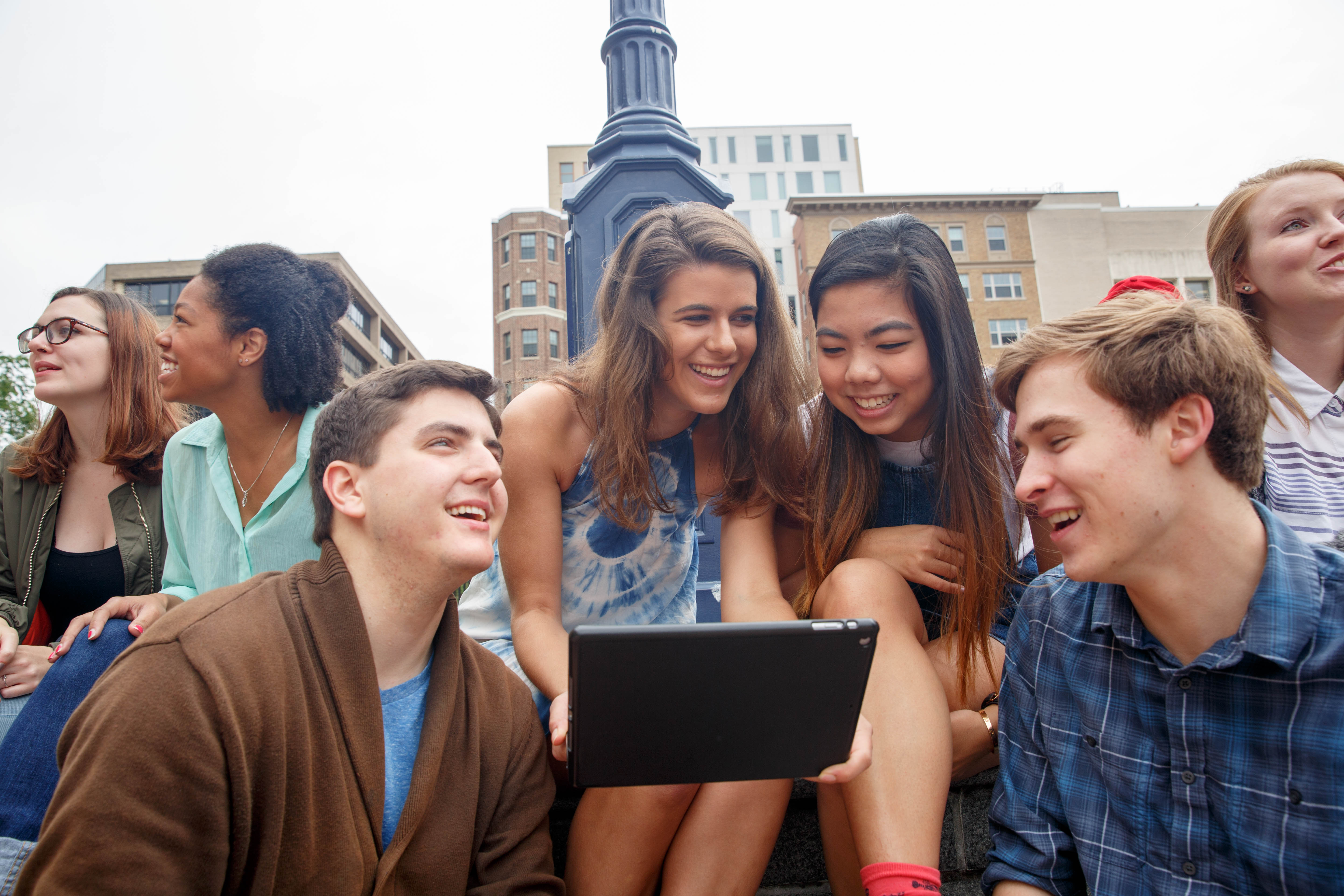 A group of friends smile together in Kogan Plaza.