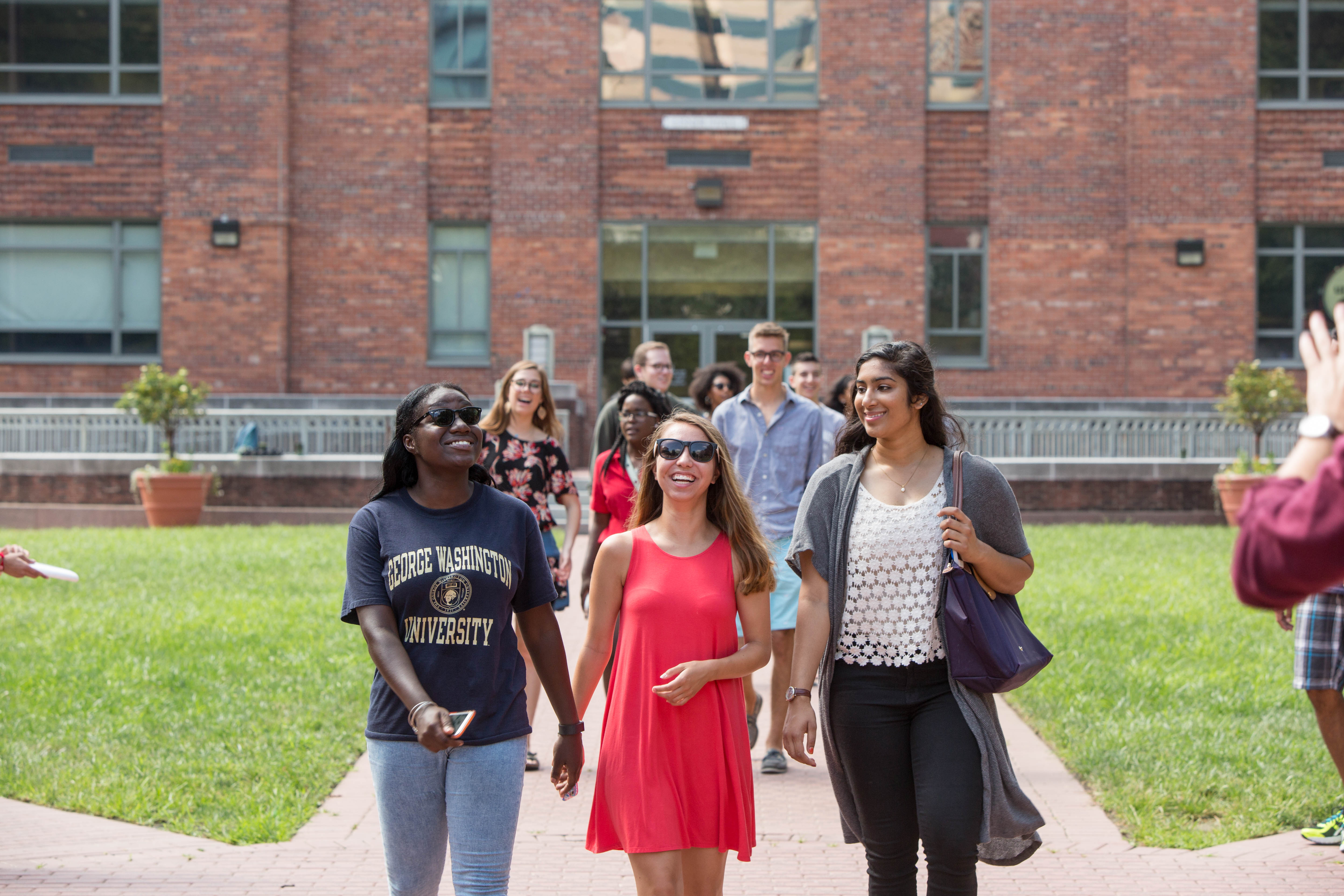 A group of friends walk together across U-yard.